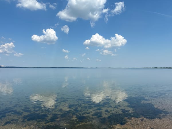 Tranquil waterfront scene captured under scattered clouds Sunday morning