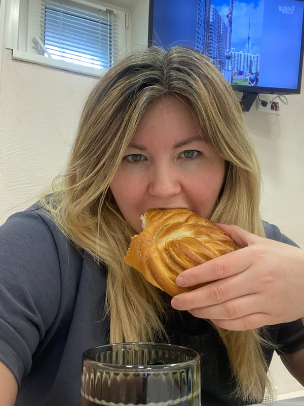 Woman enjoys breakfast pastry and drink in Chaikovsky home
