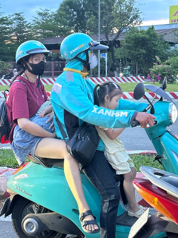 Midday motorbike traffic in Đà Nẵng, one bike hauling a tree