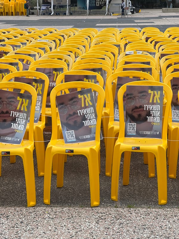 Memorial chairs with portraits displayed alongside Israeli flags in Tel Aviv