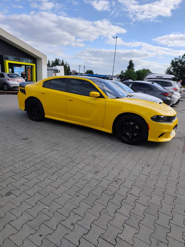 Yellow Dodge Charger Daytona parked on decorative pavers