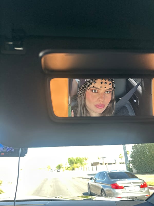 Woman in decorative headpiece spotted in car mirror, Rancho Mirage