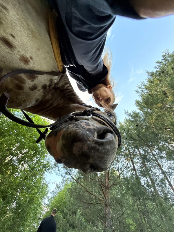 Woman enjoys horseback ride in Russian woods
