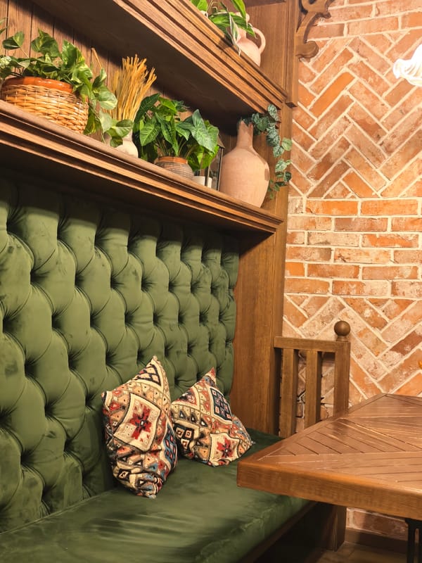 Inside a cozy rustic café with swings, velvet booths, and tea