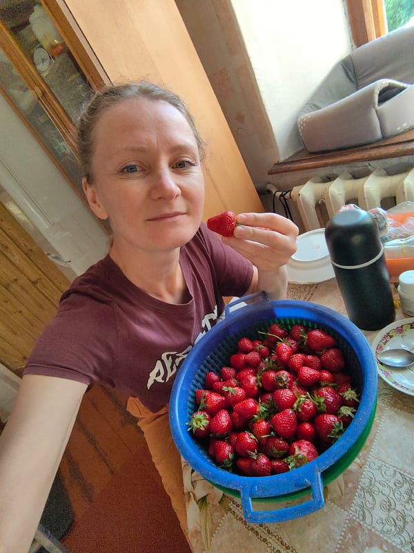 Woman enjoys strawberries, relaxes with kitten in Ukrainian village