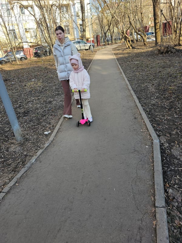 Woman and child walk with scooter on Moscow path