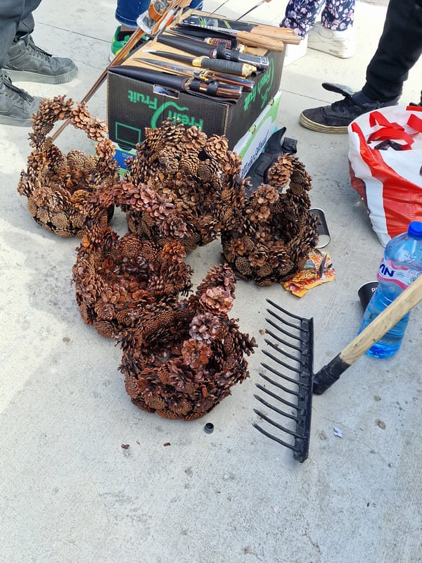 Pine cone wreaths and gardening tools arranged on concrete