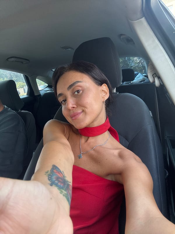 Two people inside a car in Tbilisi, brief July moment.