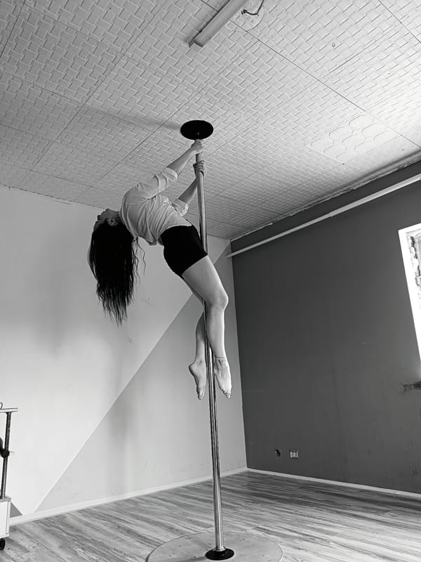 Woman performs pole dance routine in Rusalevka indoor venue