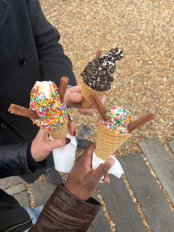 Three people enjoy ice cream cones on Folkestone boardwalk