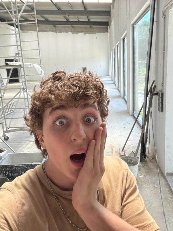 Inside a building mid-construction, concrete mixing and site walkthrough