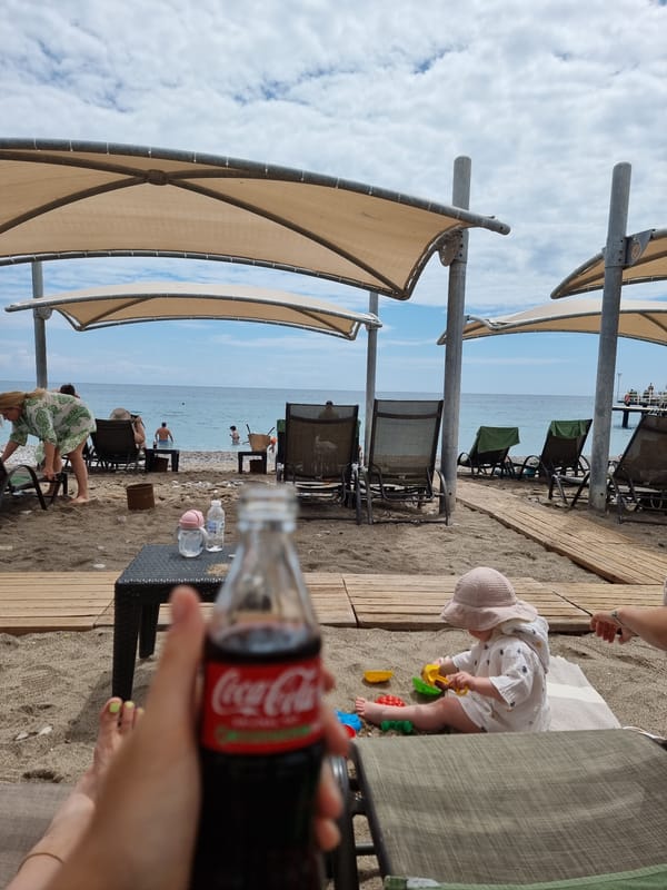 Baby in sunglasses enjoys morning at Turkish beach resort