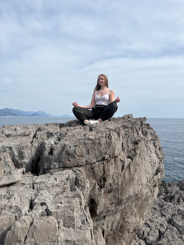 Woman sits on cliff edge in Montenegro seaside moment