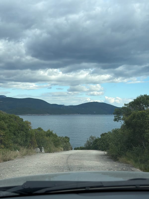 Coastal drive documented near Radovići, Montenegro under overcast skies