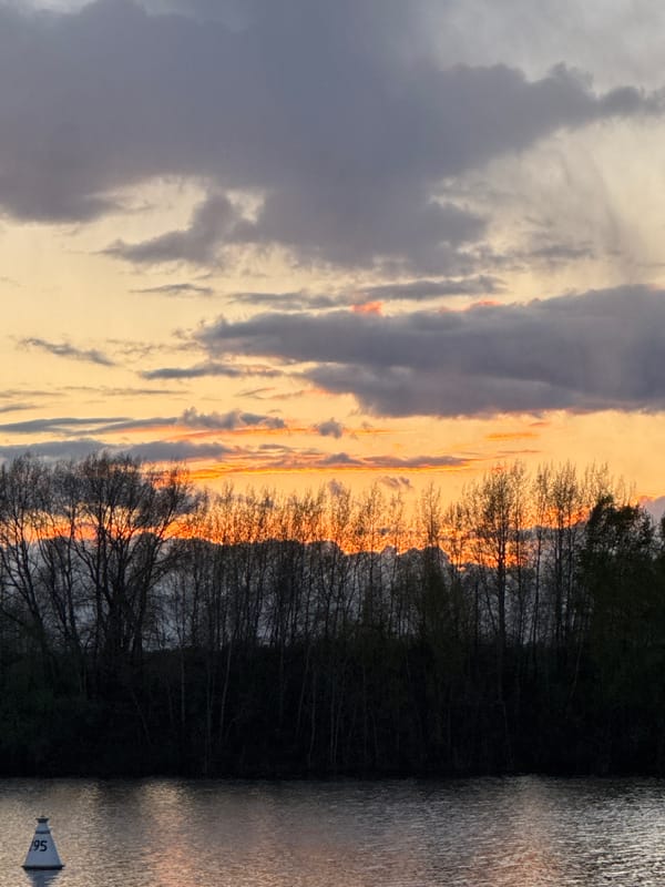 Sunset illuminates Kama River with golden clouds in Chaikovsky