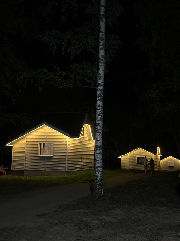 String-lit cabins glow at night in rural Galevo, Russia