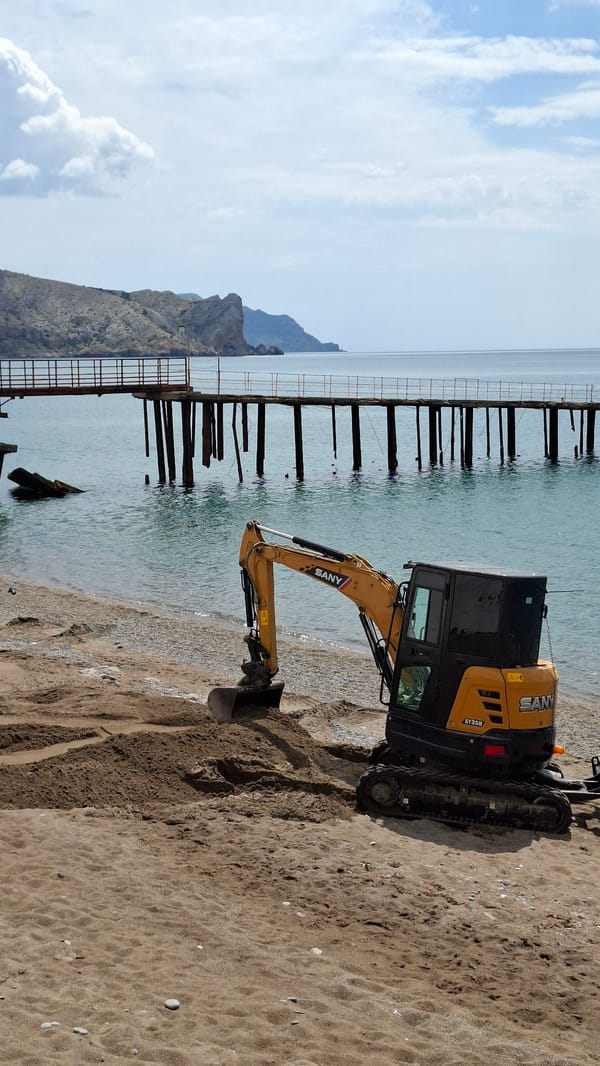 Beach excavation work draws curious onlookers at coastal location