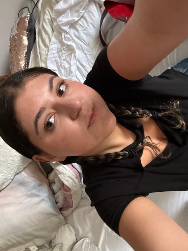 Woman takes overhead selfie on bed in Mexico City