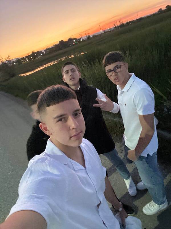 Three men pose for photo during sunset in Greece