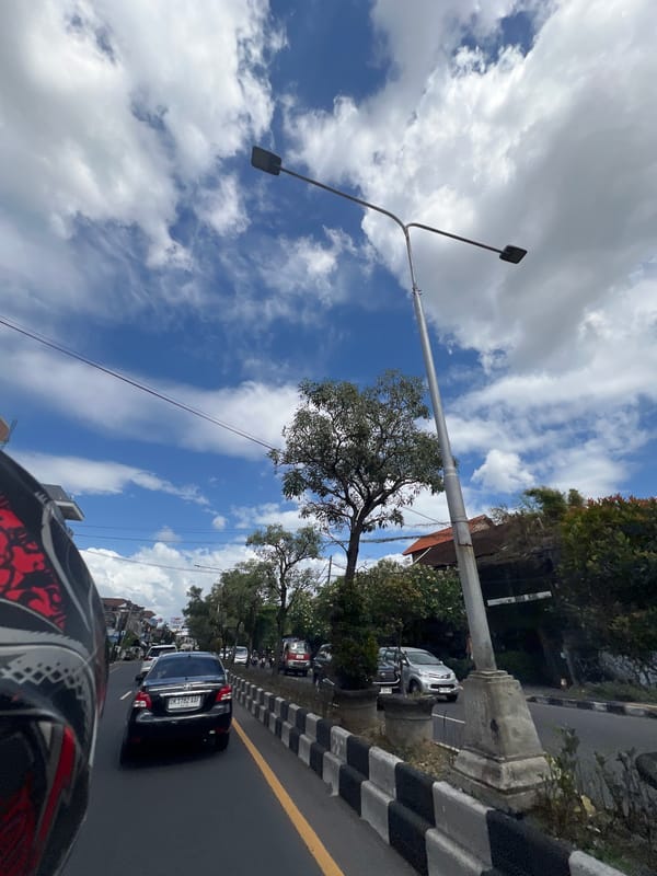 Motorcycle street scenes rolling through cloudy Denpasar