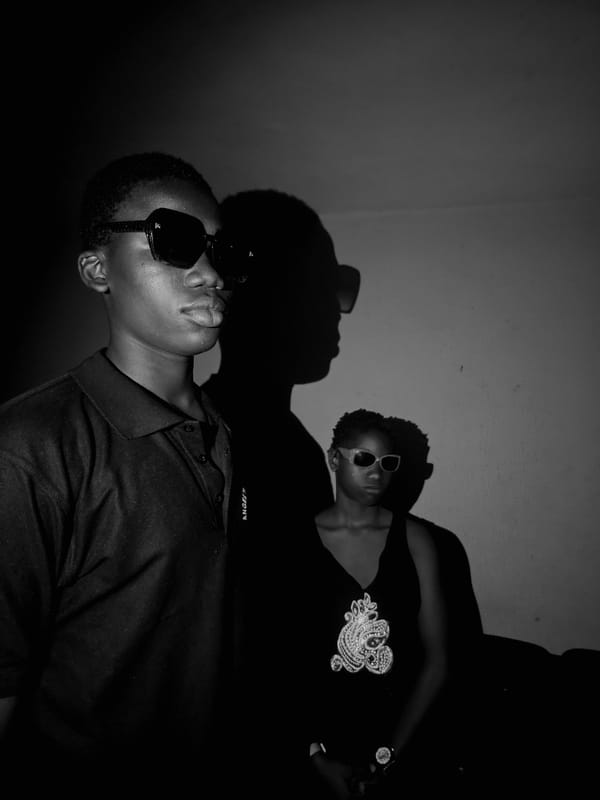 Two people photographed indoors wearing glasses and shirts