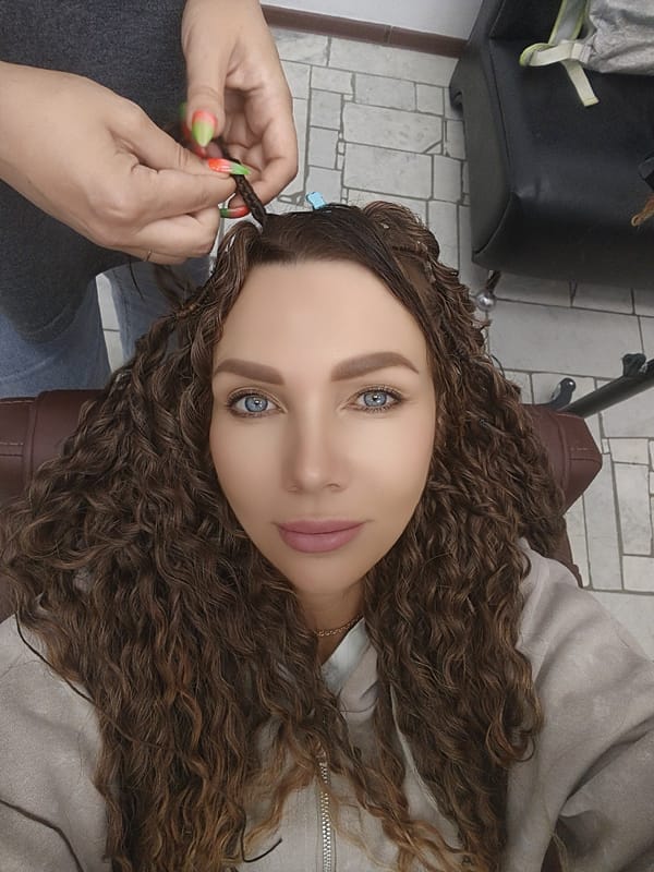 Woman receives hair styling session at salon