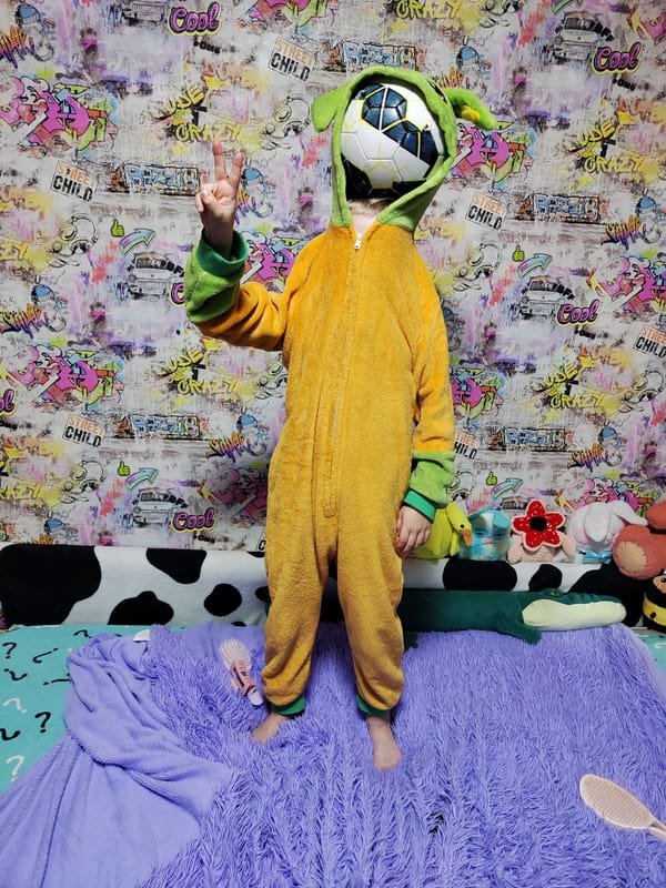 Child plays with soccer ball on bed in Kuyeda