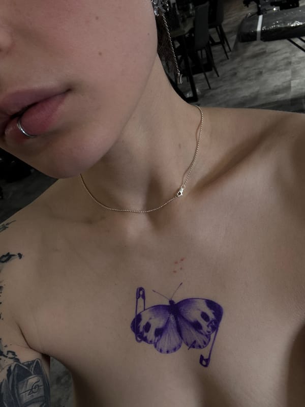 Person displays butterfly tattoo with safety pins in Moscow