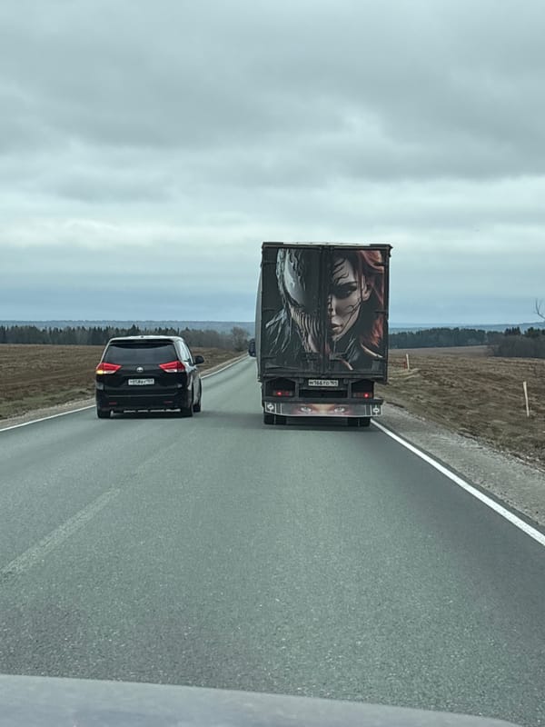 Vehicles travel highway in Perevoznoe, Russia under overcast skies