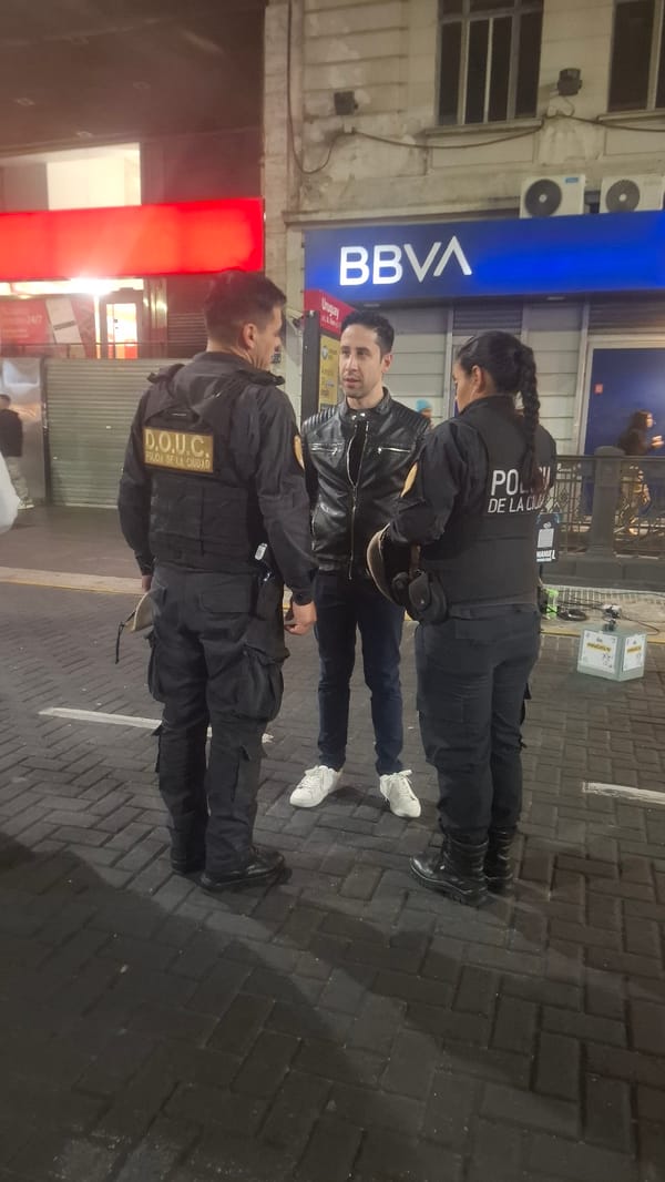 Street performer sings outside Buenos Aires bank at night