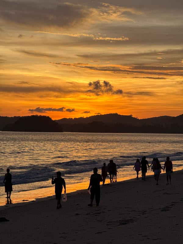 Sunset beach gathering with fireworks in Thailand