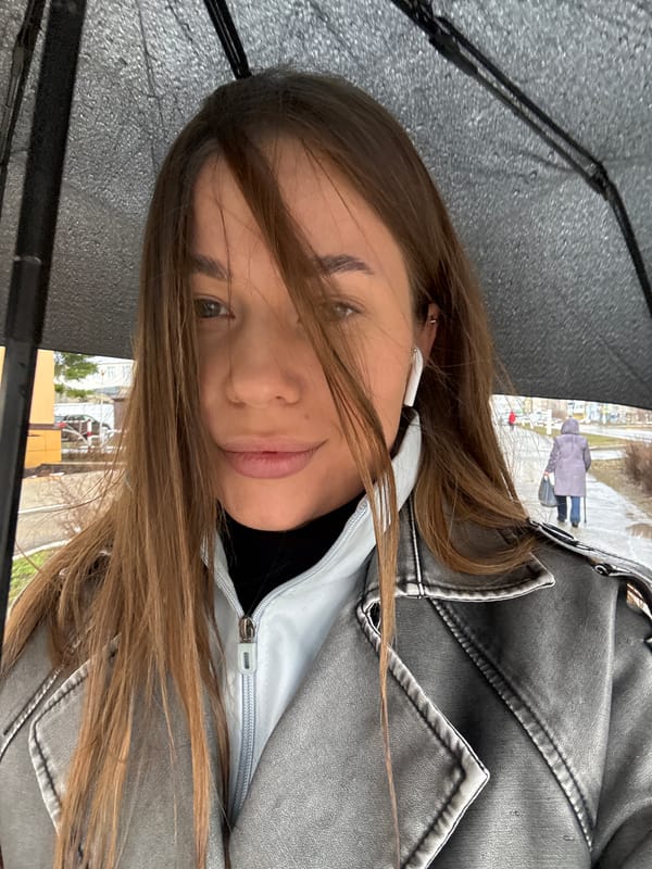 Person with umbrella navigates wet streets in Chernushka, Russia