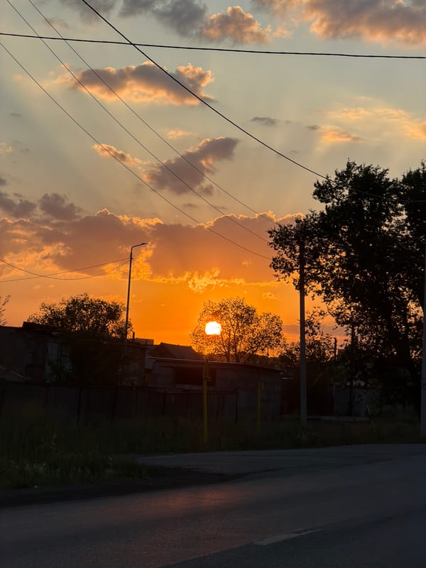 Vivid orange sunset silhouettes Temirtau's skyline infrastructure