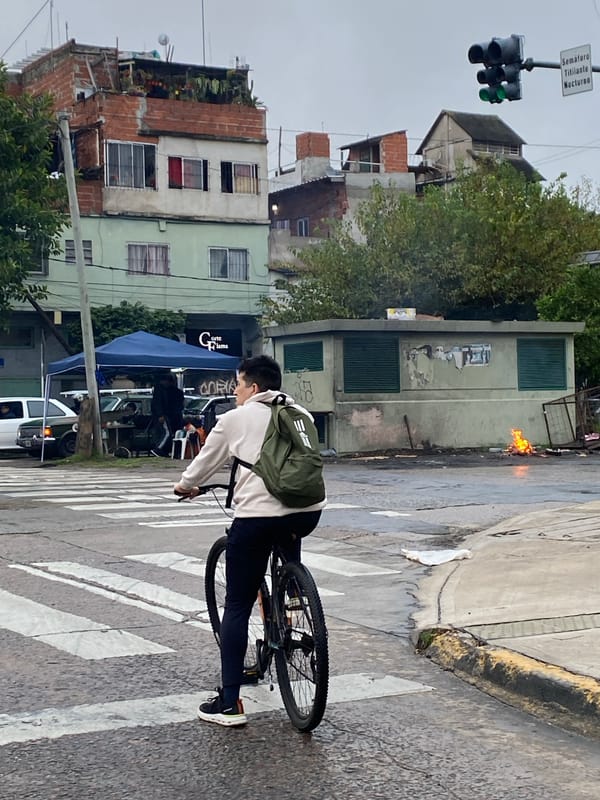 Cyclist rides on wet Buenos Aires street after rain