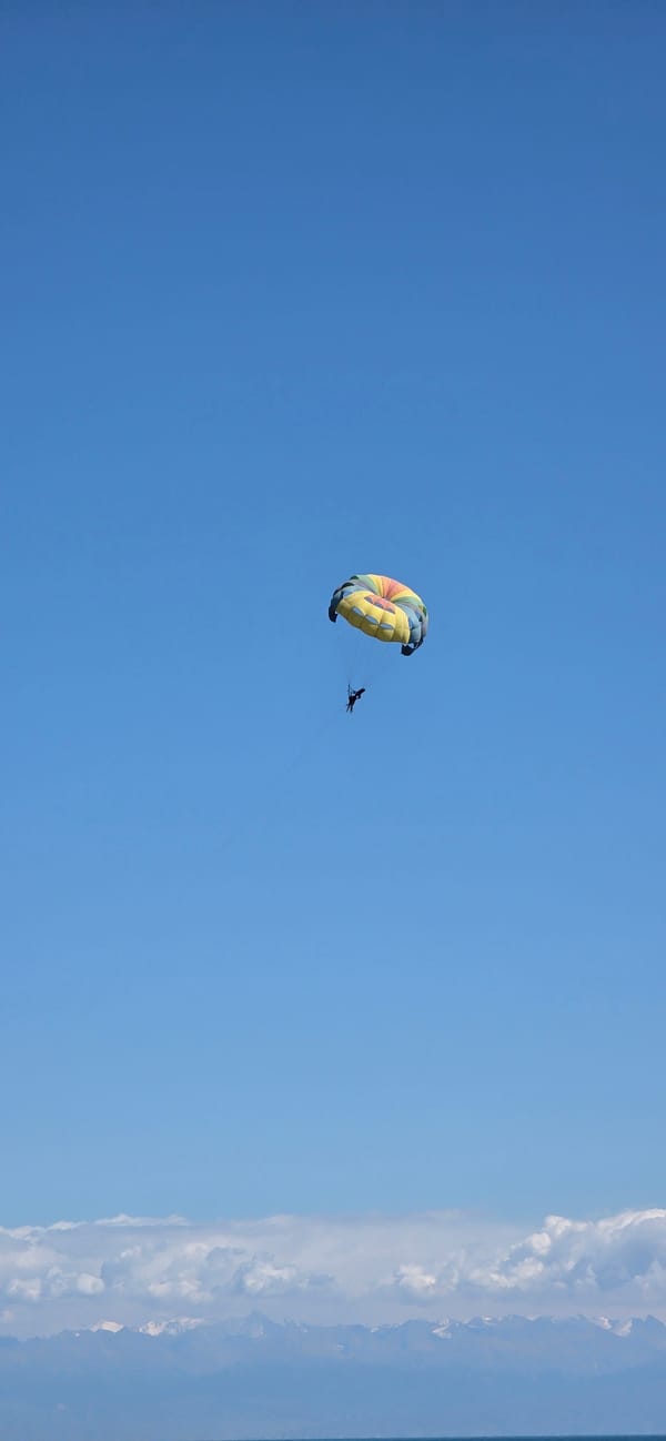 Summer day at a Kyrgyz lakeside beach with parasailing