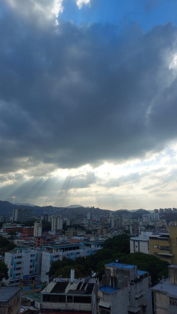Dramatic storm clouds contrast with bright skies over Caracas