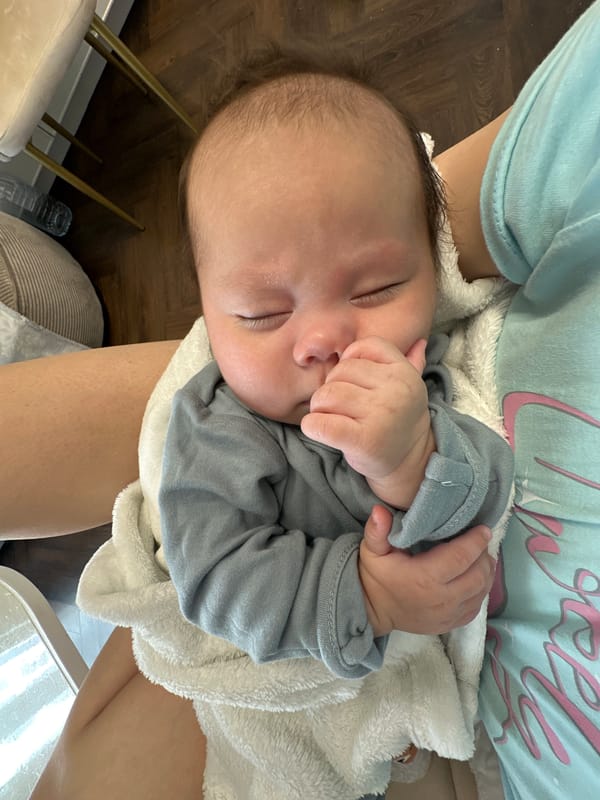Infant sleeps peacefully in adult's arms during quiet afternoon moment