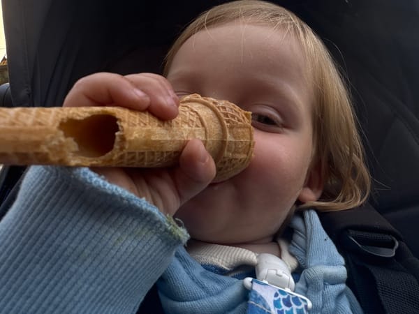 Toddler enjoys ice cream cone in stroller in Erba