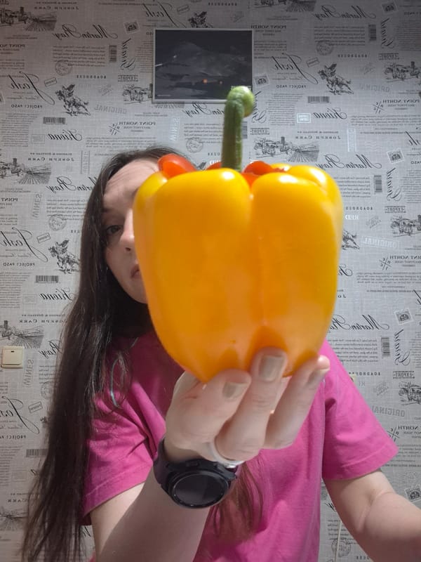 Person Creates Whimsical Bell Pepper Sculptures, Poses Playfully