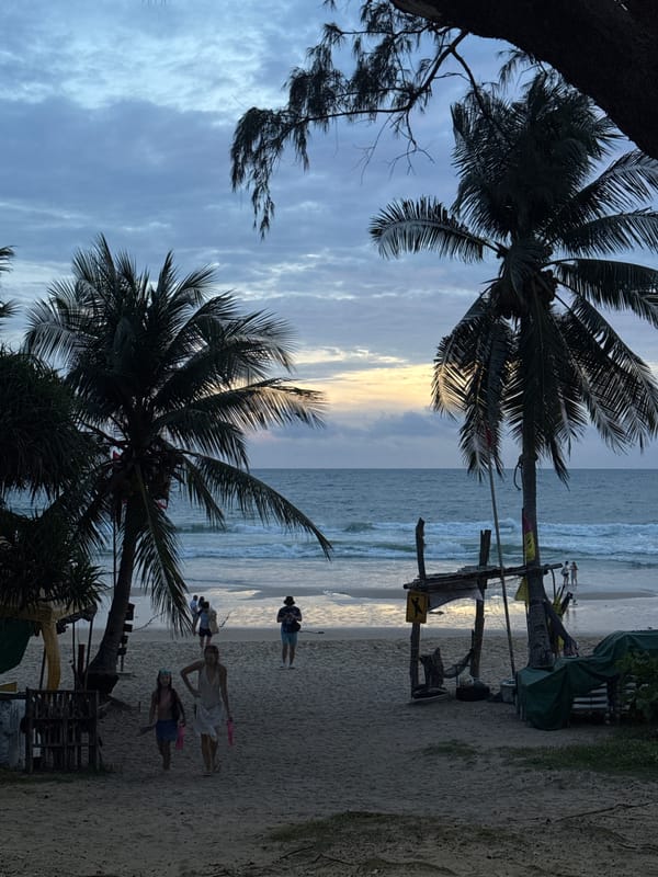 Karon Beach at dusk: shoreline calm, streets quietly moving