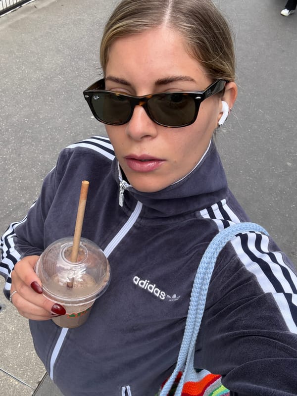 Woman takes selfie while drinking on Paris street
