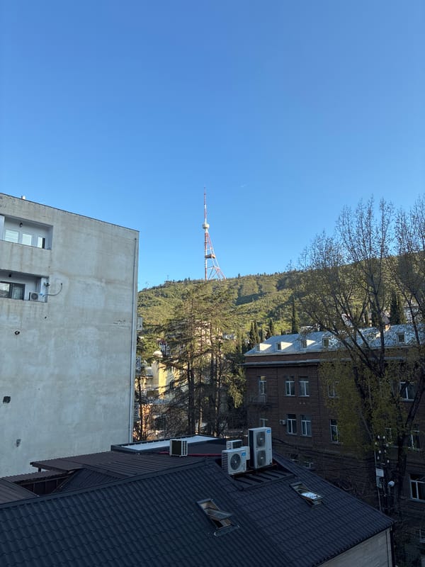 Clear skies frame Tbilisi cityscape with telecommunications tower