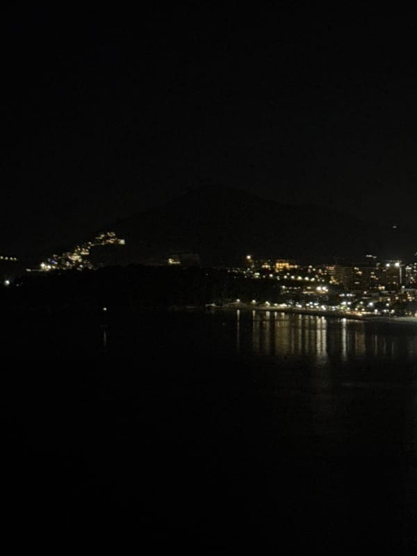 Nighttime aerial views capture illuminated Rafailovići coastline under full moon