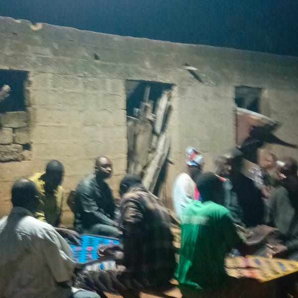Men gather for nighttime board game in Akwanga, Nigeria
