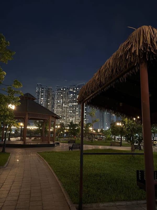 Nighttime hang at a Hanoi waterfront park beside rising towers