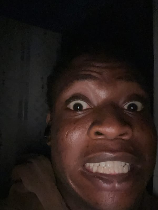 Person photographed making animated expressions during late-night session