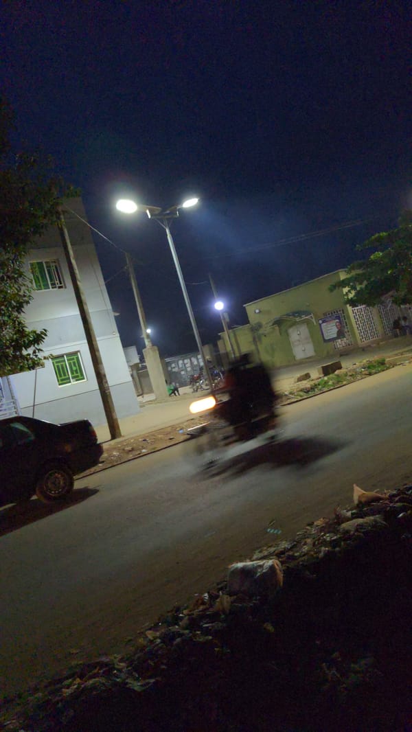 Nighttime street market bustles with vendors in Ado, Nigeria