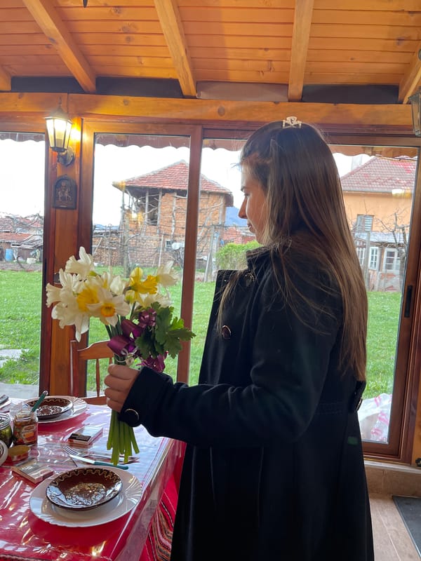 Person with crown holds spring bouquet in Varshets, Bulgaria