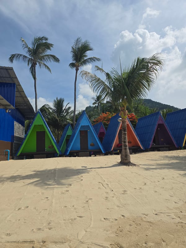 Colorful cabins, a beached boat, and calm water at Baan Lamai
