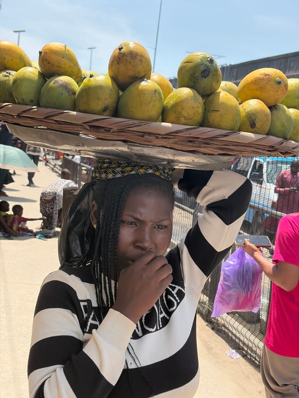 Street vendor sells mangoes from head basket in Lekki